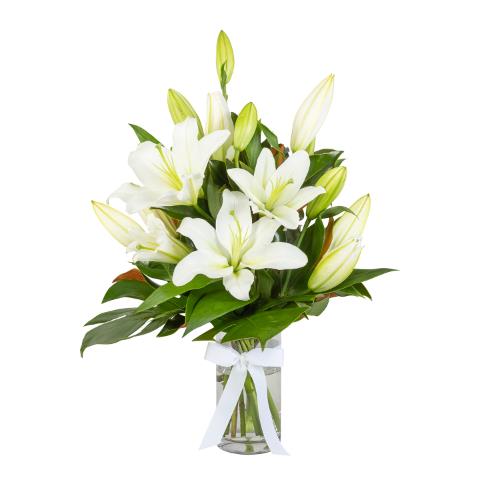 A modern creation of a lily bouquet with greenery arranged in a glass vase. Sympathy lilies' use of...