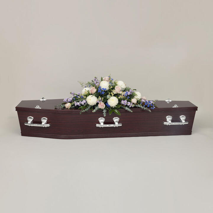 Pastel Casket Flowers presents a delicate and loving tribute adorned with a selection of blooms. This...