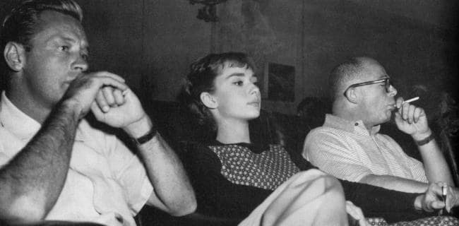 Director Billy Wilder (right) with actors William Holden and Audrey Hepburn watching rushes of film Sabrina in 1954.