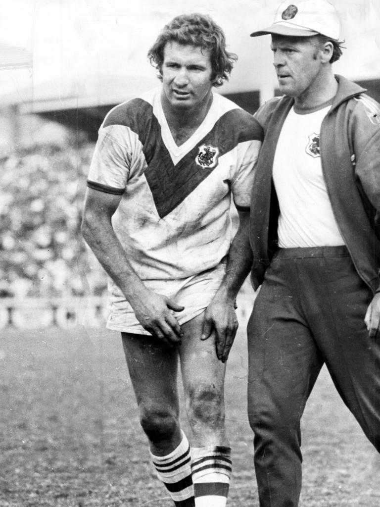 Graeme Langlands is assisted from the field during the 1975 grand final.