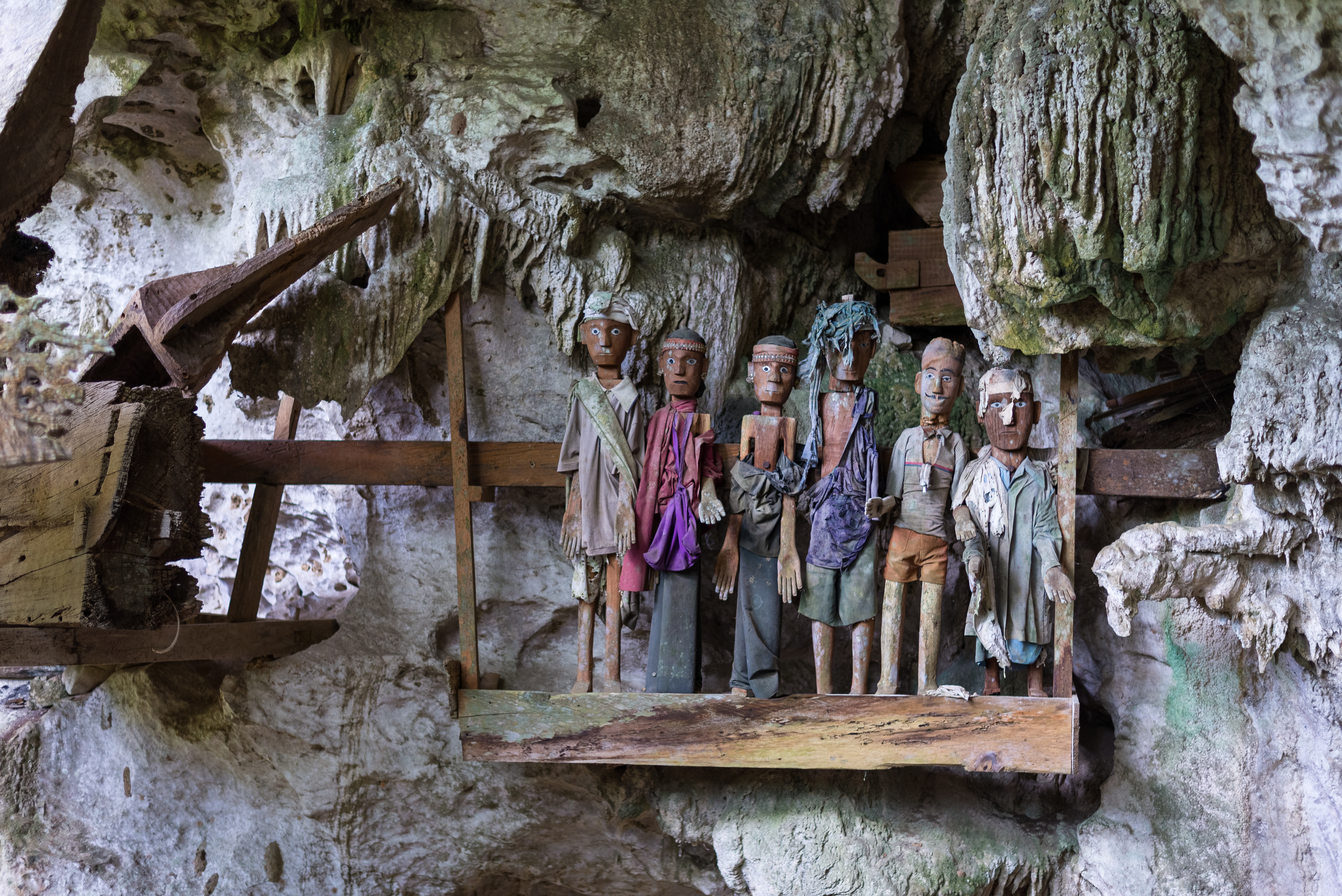 Row of dressed wood statues (called tau tau in local language) on a balcony inside the fascinating cave of the traditional burial site at Tampangallo, Tana Toraja, South Sulawesi, Indonesia.
