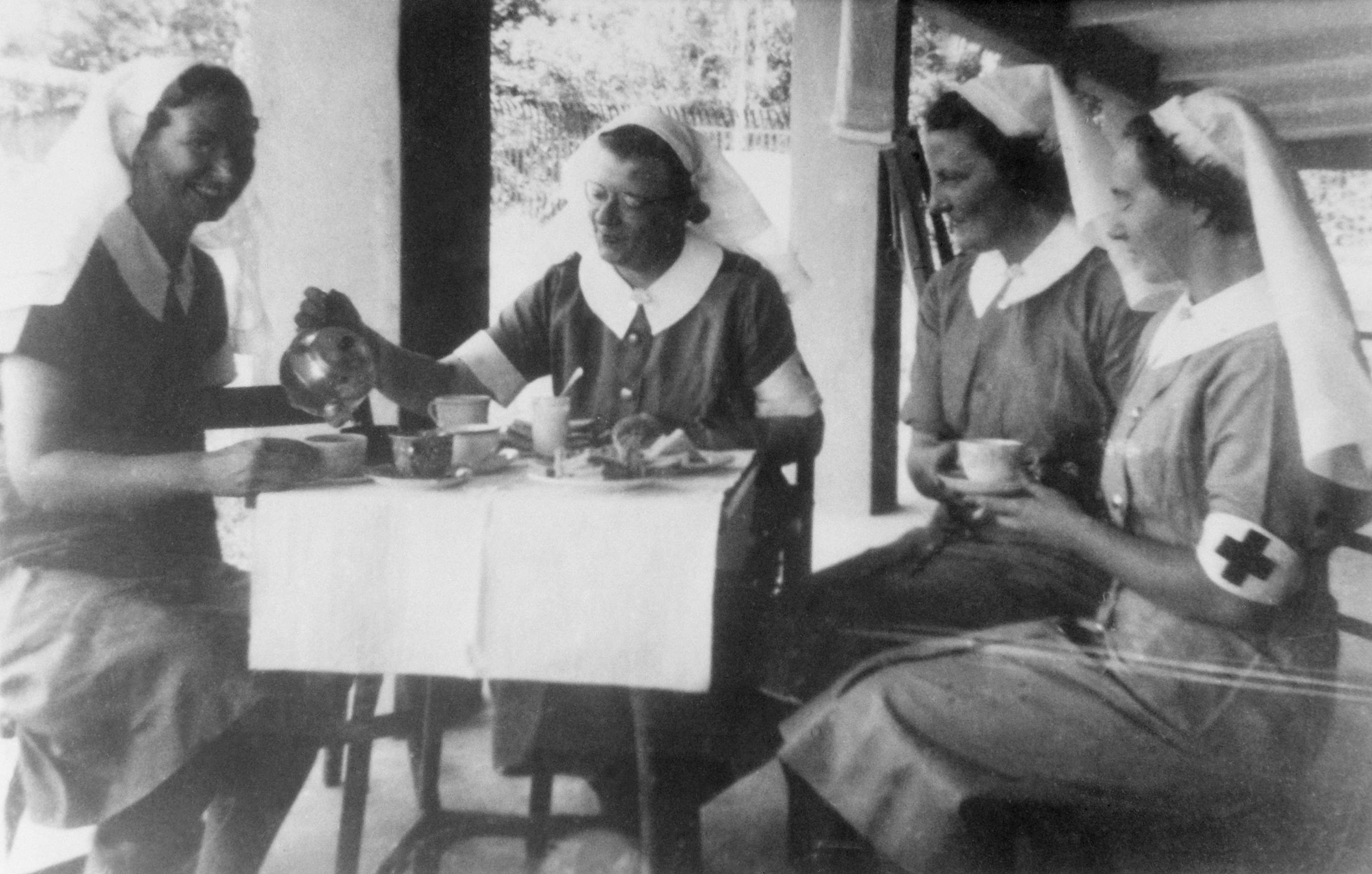Four sisters of the 2/13th Australian General Hospital enjoying a cup of tea. (left to right): Sister Vivian Bullwinkel; Matron Irene Drummond; Sr M Anderson; Sr M Selwood. 
