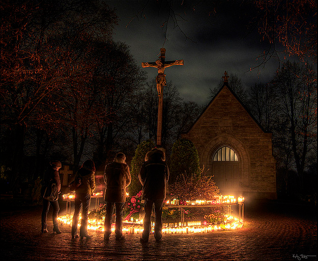This photograph depicts four young adult Lutheran Christians praying to God on the night of All Hallows' Eve (Halloween) for Christian martyrs, saints, and all the faithful departed, especially their loved ones, in preparation for All Hallows' Day (All Saints' Day), the following day of Hallowtide.
