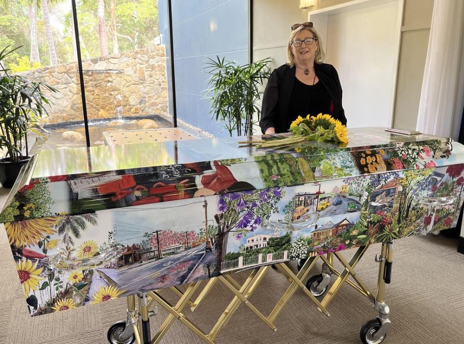 Kathleen Allam's casket was covered with pictures of her colourful artwork. Her funeral was held at the Hemmant Cemetery chapel on June 7, 2023.
