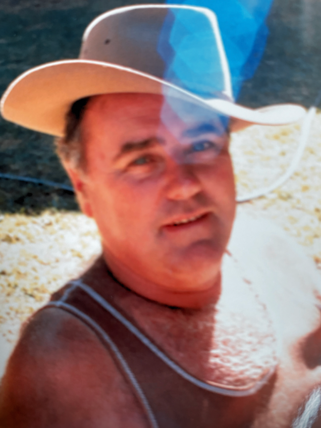 Ken keeps the sun out of his eyes in the backyard of the family house in Alice Springs in 1987.